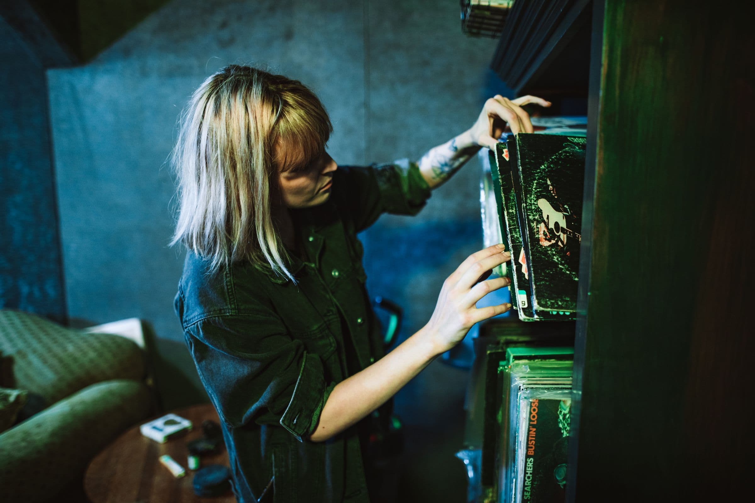 Woman pulling a vinyl record from a shelf of records