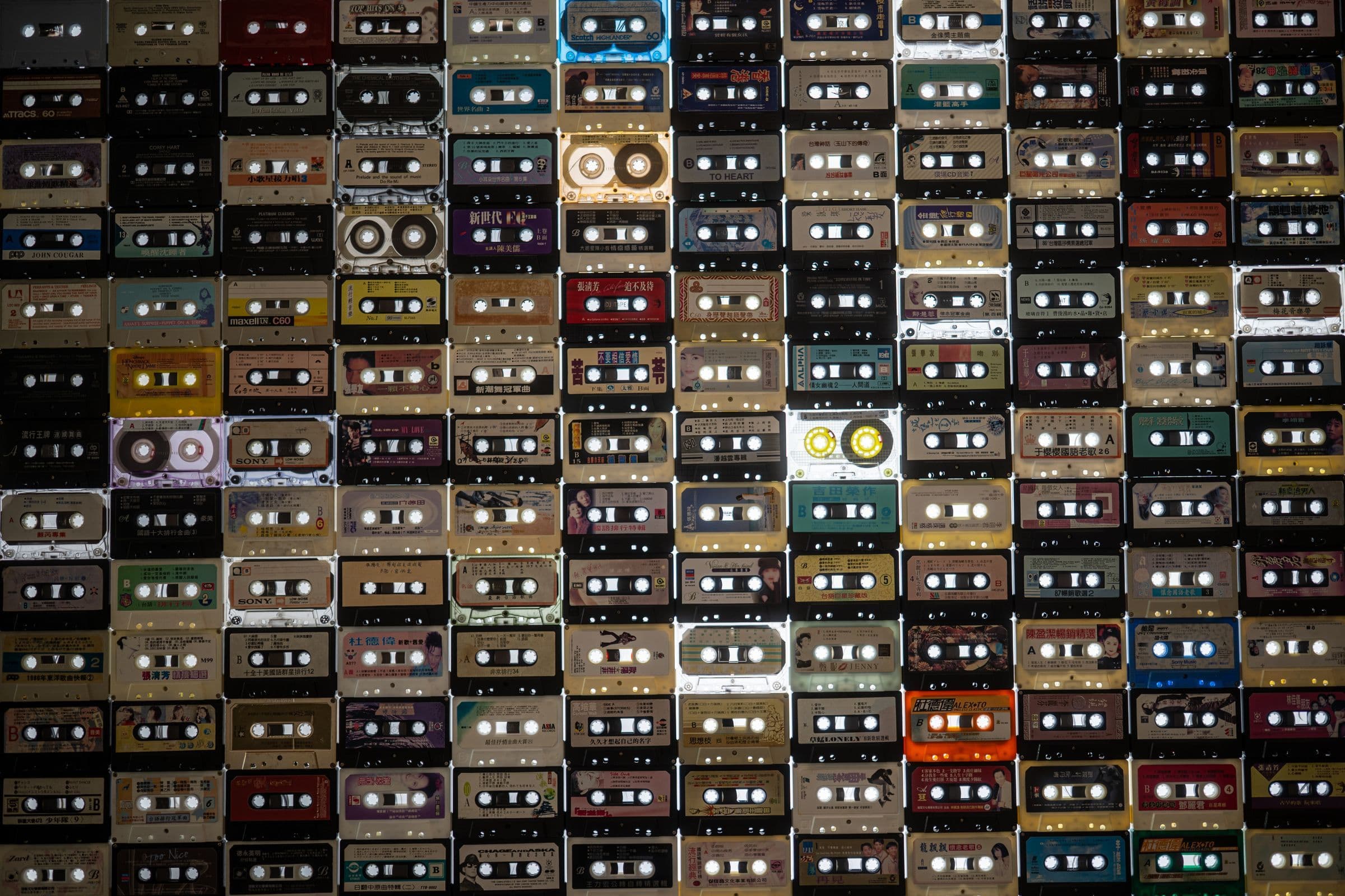 Wall display of colorful vintage cassette tapes in neat rows